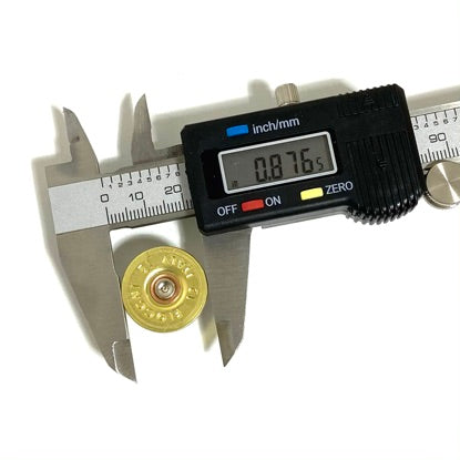 A digital caliper measuring the outside diameter of a gold 12 gauge shotgun shell headstamp, reading 0.876 inches.
