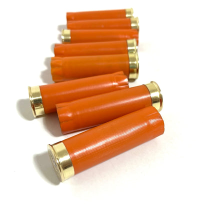 Close up of unlabelled orange plastic texture on 12 gauge shotgun shells with gold bottom once fired casings.
