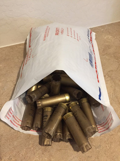 Gold Remington Nitro empty 12 gauge shotgun shells spilling out of a Priority Mail shipping envelope