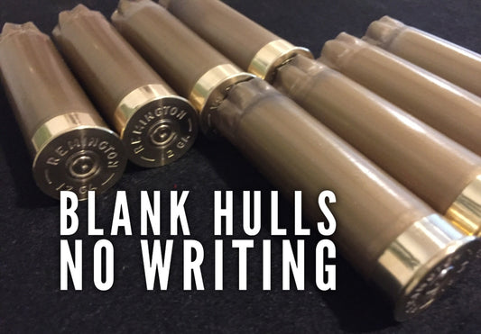Six gold 12 gauge shotgun hulls on dark surface with REMINGTON headstamps and white BLANK HULLS NO WRITING text overlay.
