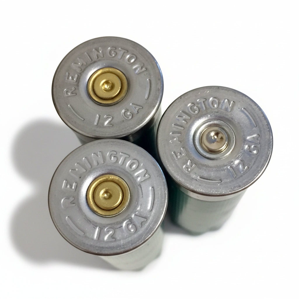 Three empty green 12ga Remington Gun Club hulls with headstamps visible on a marble countertop