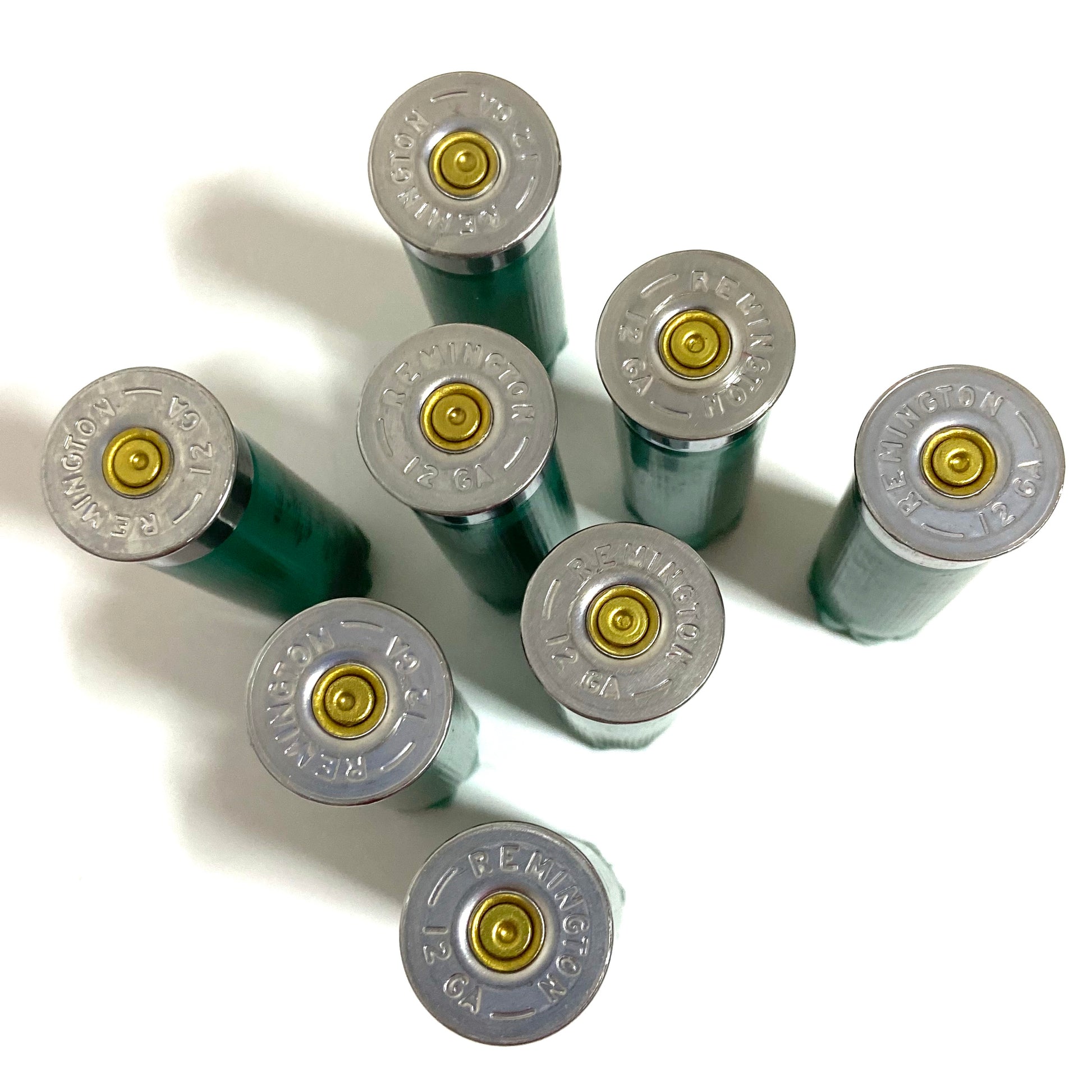 Seven once-fired green 12ga Remington Gun Club casings viewed from above showing REMINGTON 12 GA headstamps
