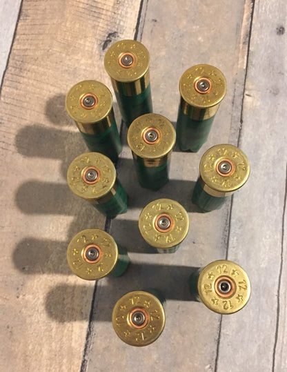 9 empty green 12 gauge shotgun shells viewed from above showing brass headstamps marked 12