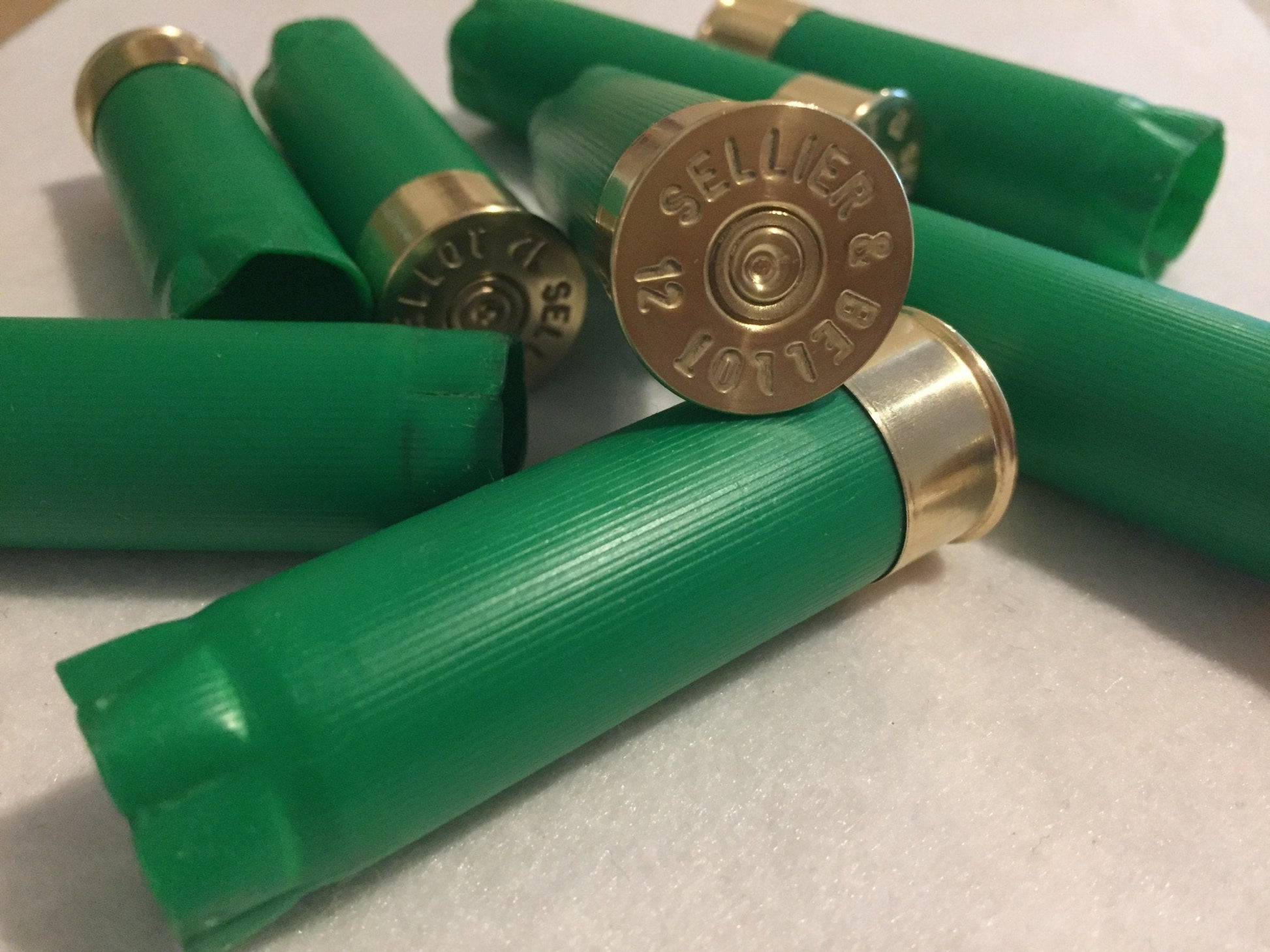 Green Sellier and Bellot 12 gauge shotgun shells clustered together showing a gold brass head with headstamp text