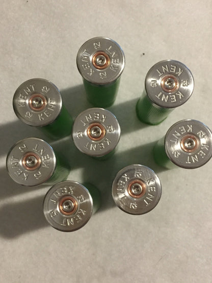 7 empty lime green 12 gauge shotgun shells viewed from above showing silver Kent headstamps
