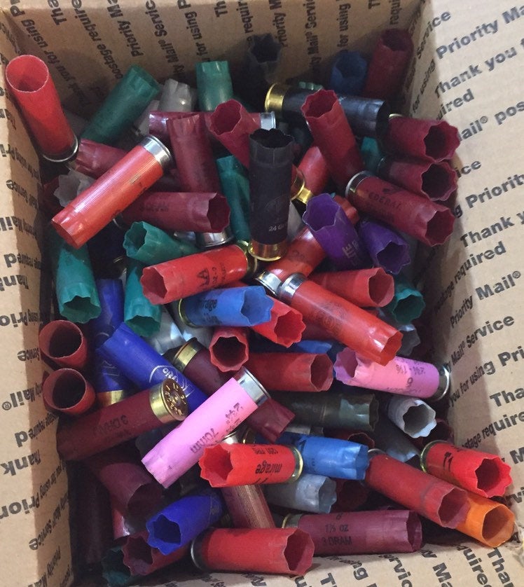 Loose-packed mixed-color spent 12 gauge shotgun shells viewed from above