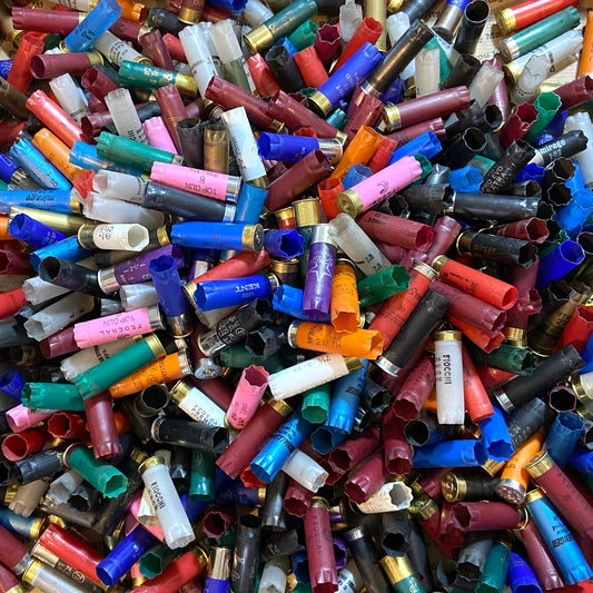 Pile of mixed color 12ga shotgun hulls. Inert 12ga shells for crafts (no powder/spent primers).
