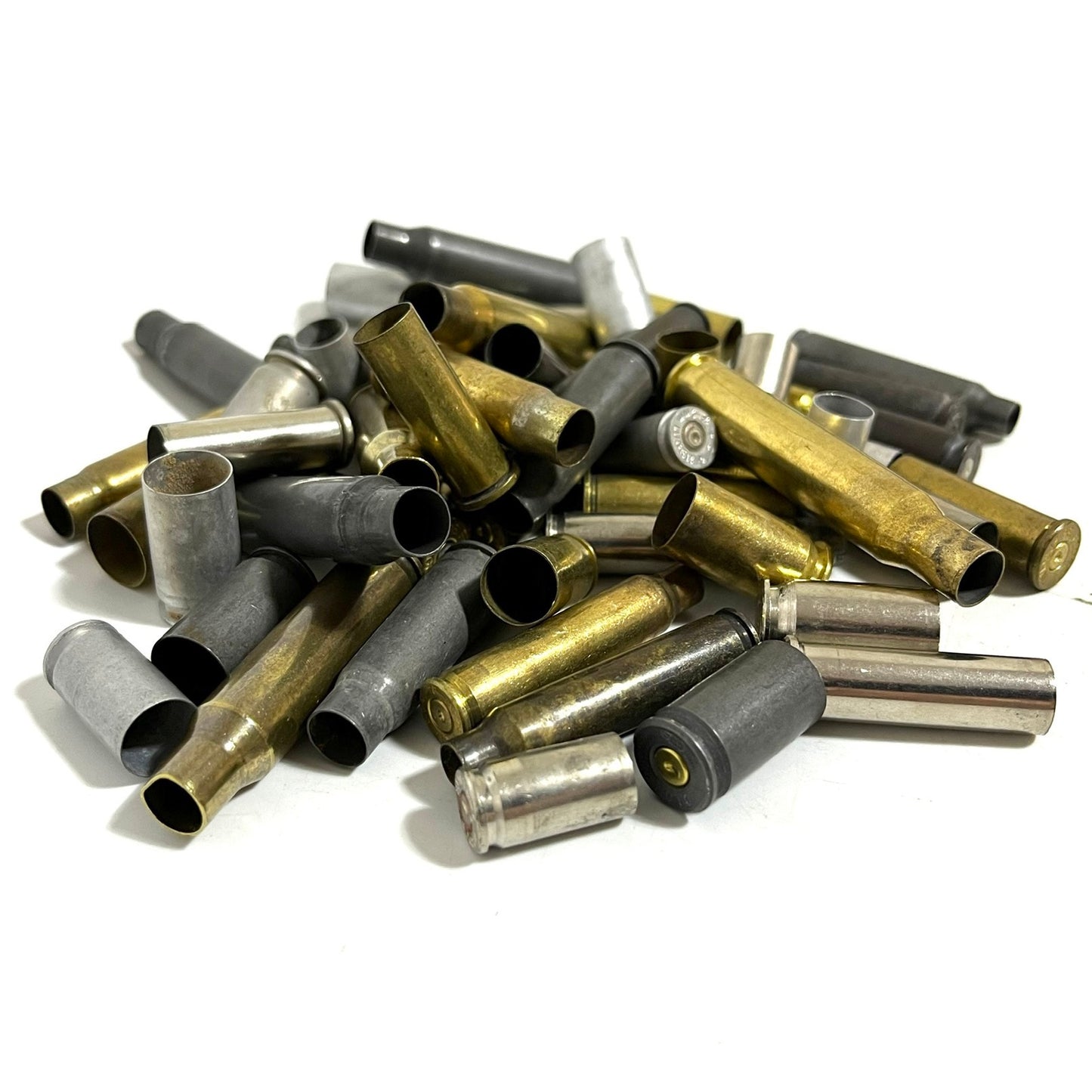 Heap of mixed spent cartridges in nickel, steel, and brass on a white background.