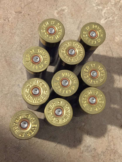 9 empty navy blue 12 gauge shotgun shells viewed from above showing brass Clever headstamps