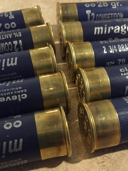 Empty navy blue 12 gauge Clever Mirage shotgun shells with brass bases showing headstamps and printed markings on a stone surface
