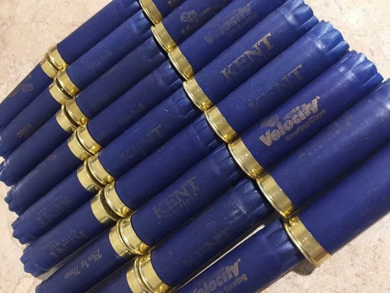 Rows of navy blue Kent and Velocity 12 gauge shotgun shells with gold bottoms
