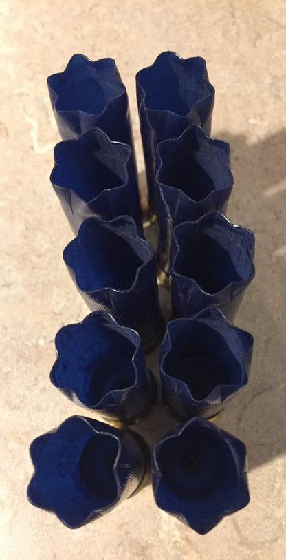 10 navy blue shotgun shells viewed from open crimped end from above, star-shaped crimp openings in two rows