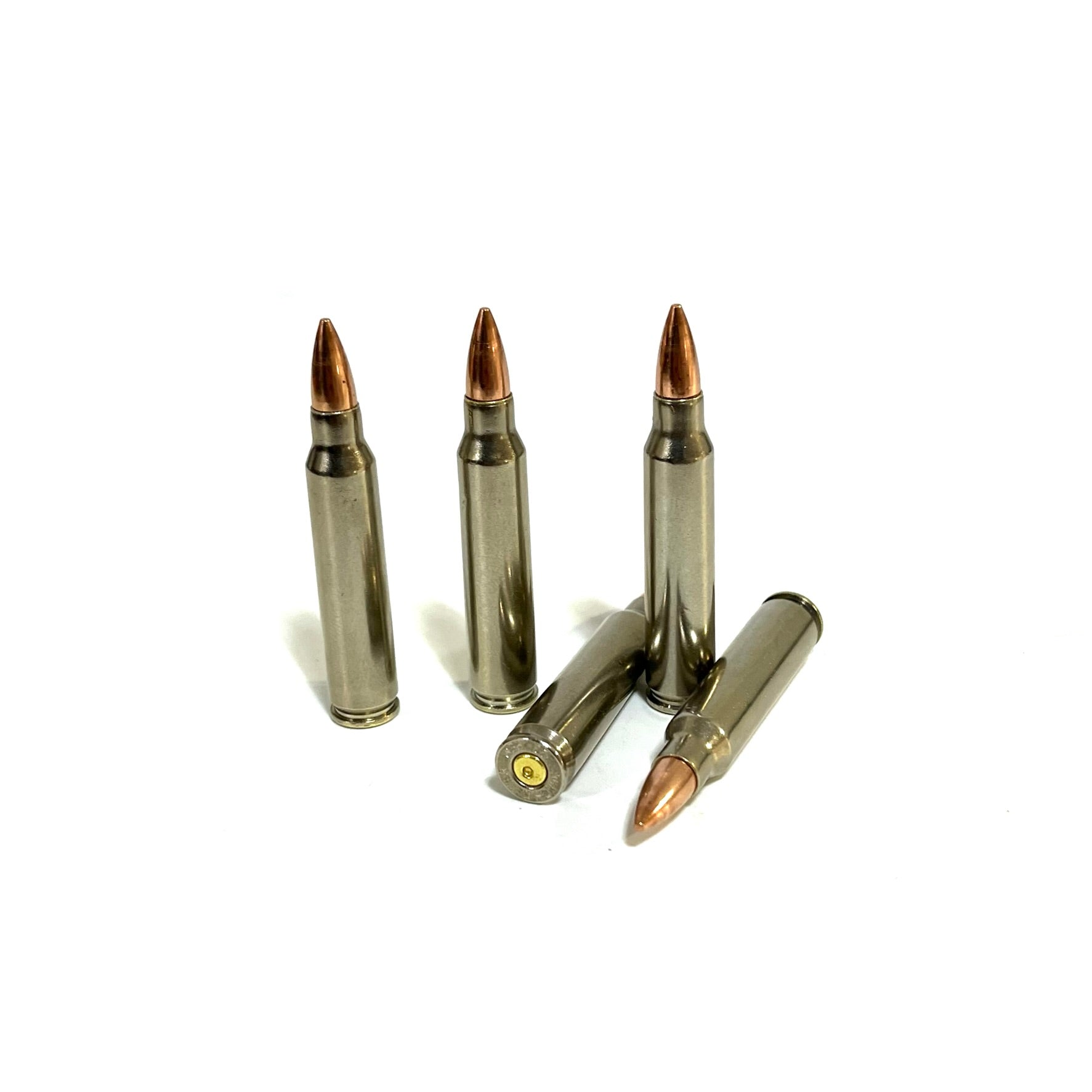 Five nickel-plated .223 dummy rifle cartridges clustered together with one lying in front showing base rim and primer.