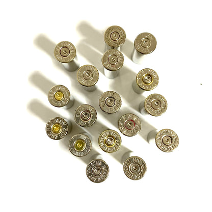 Sixteen silver nickel .357 Magnum headstamps from various manufacturers viewed from above, showing mixed brand stampings