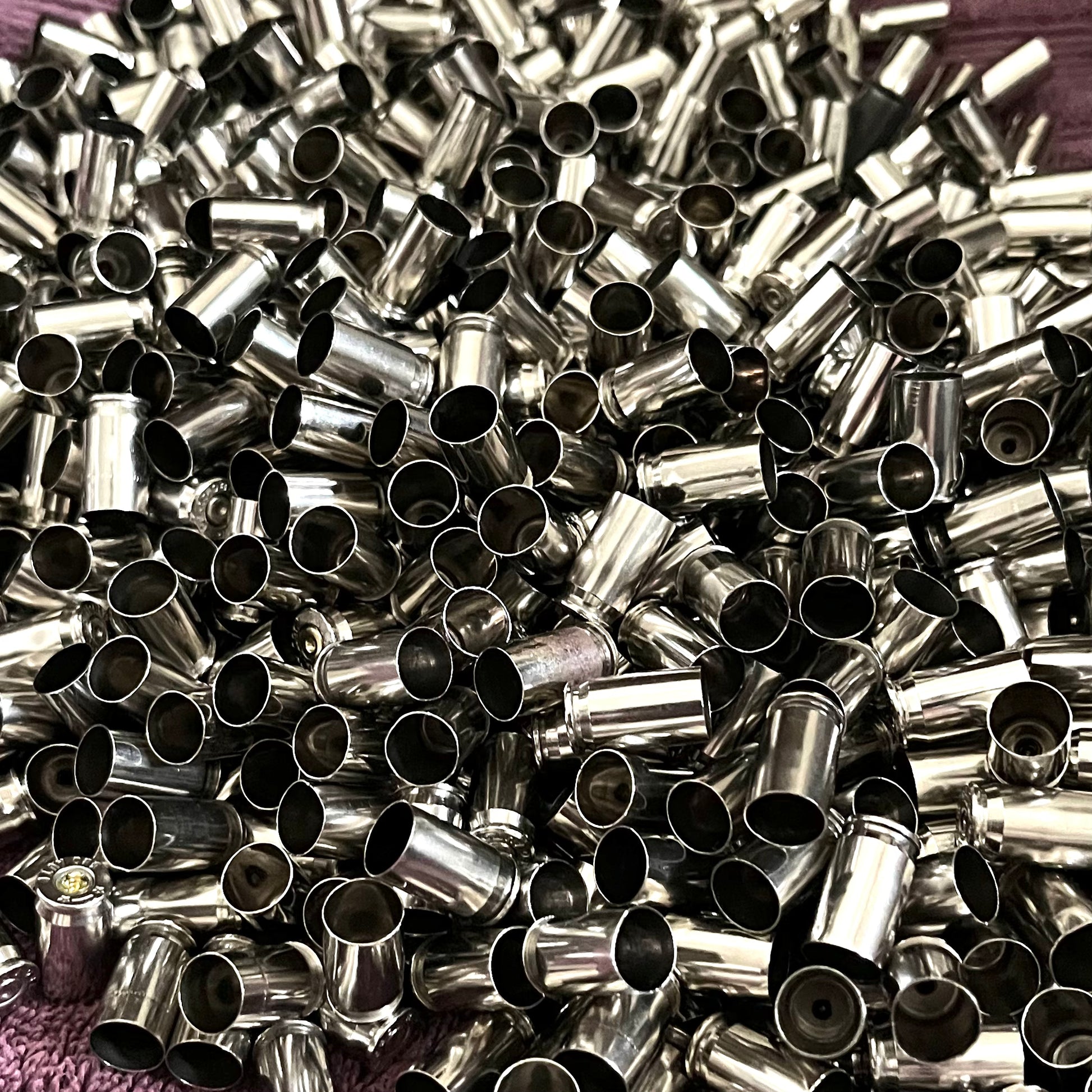 Nickel .380 Auto brass casings, once-fired empty shells. These are inert with no powder or live primers, ideal for rustic jewelry and crafting.
