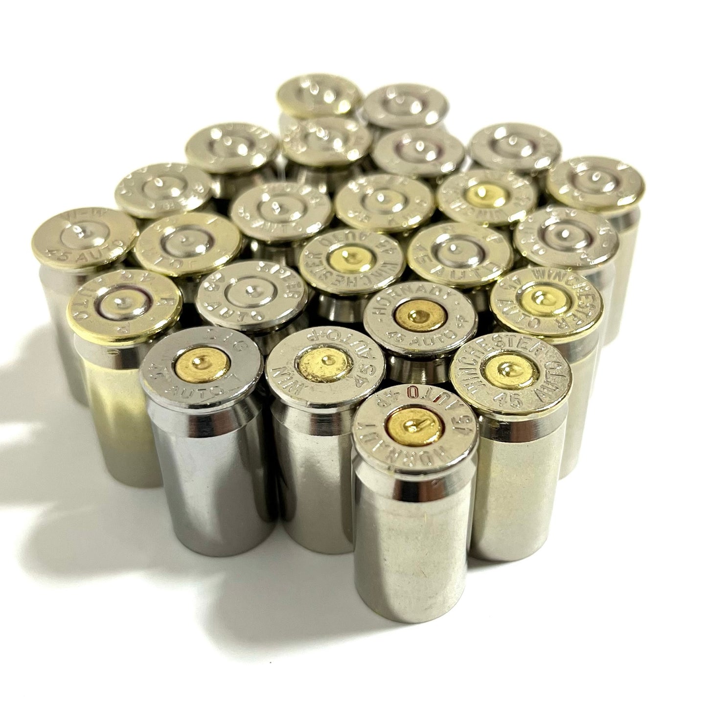 Cluster of nickel 45 ACP empty casings viewed from above showing brass primers and mixed headstamps