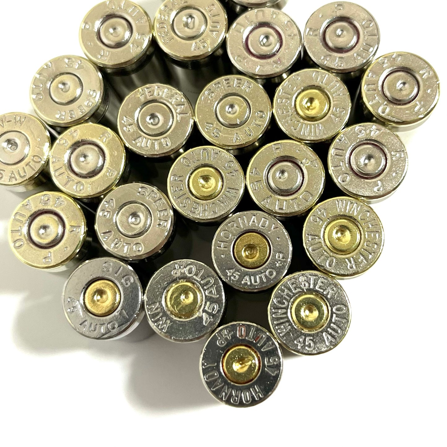 Cluster of nickel 45 ACP empty casings viewed from above showing mixed brand headstamps and primers