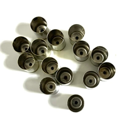 Cluster of nickel 45 ACP empty casings viewed base-down showing small drilled center holes