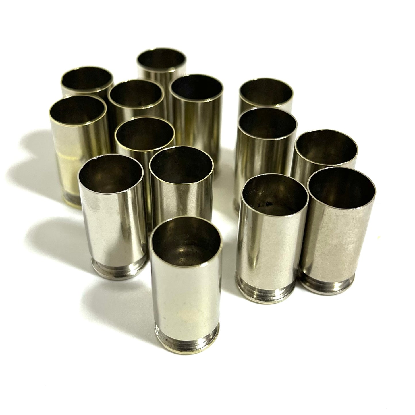 Cluster of nickel 45 ACP empty casings viewed open-end up on a white background