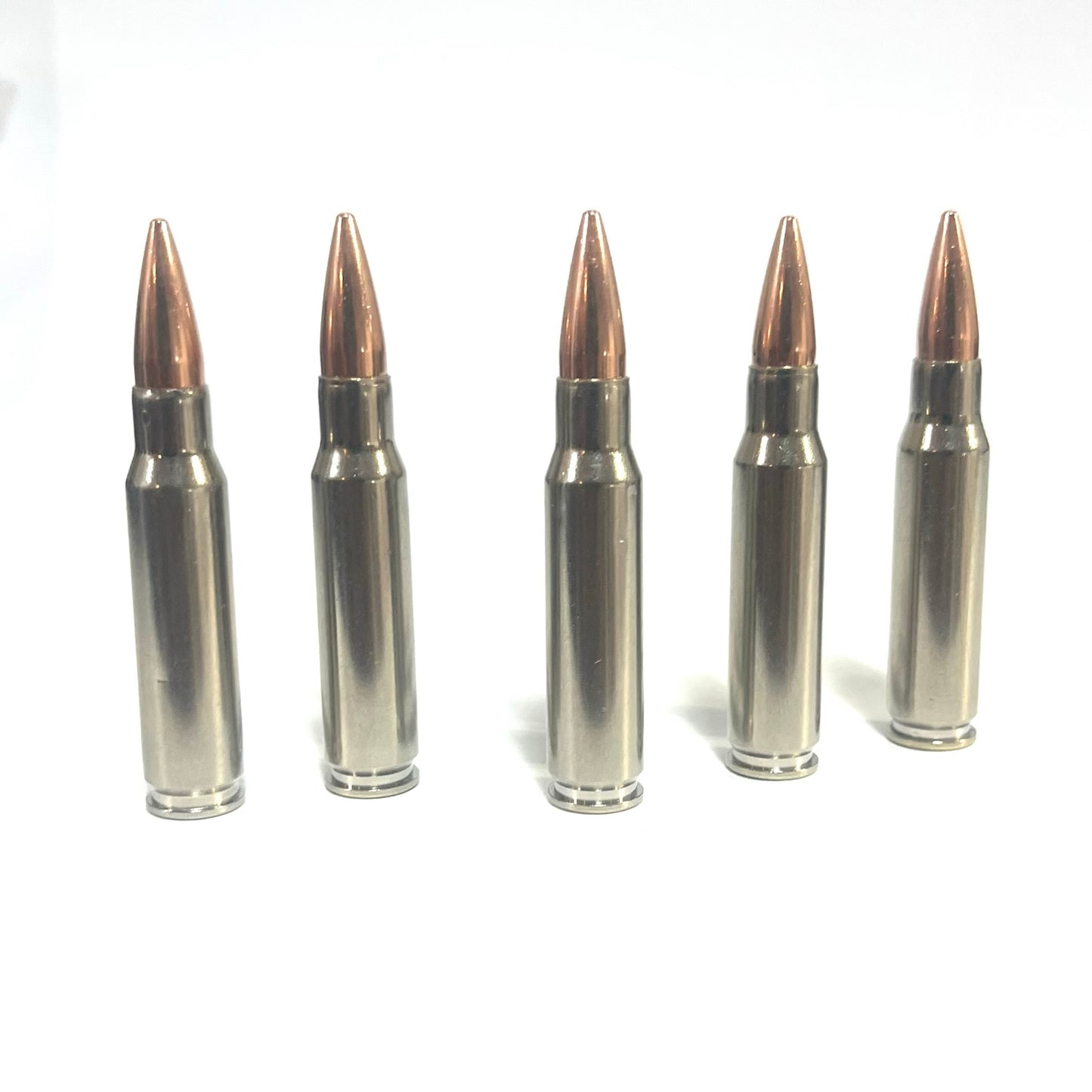Five nickel-plated .308/7.62x51 dummy rounds standing upright in a row with a knurled ring near each base
