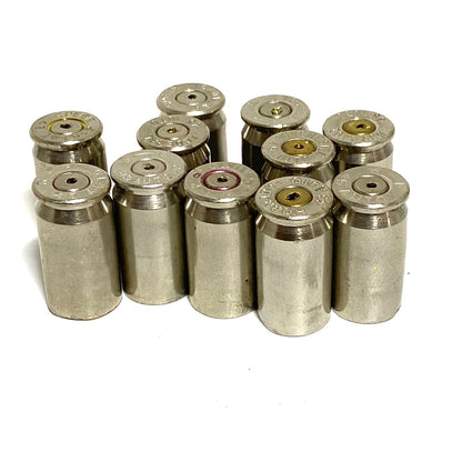 Eleven used nickel 45 ACP shells standing in a cluster, headstamps and drilled primers facing up