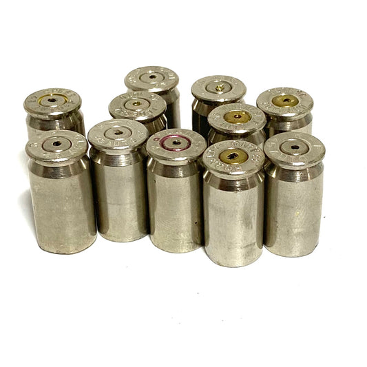 Eleven used nickel 45 ACP shells standing in a cluster, headstamps and drilled primers facing up