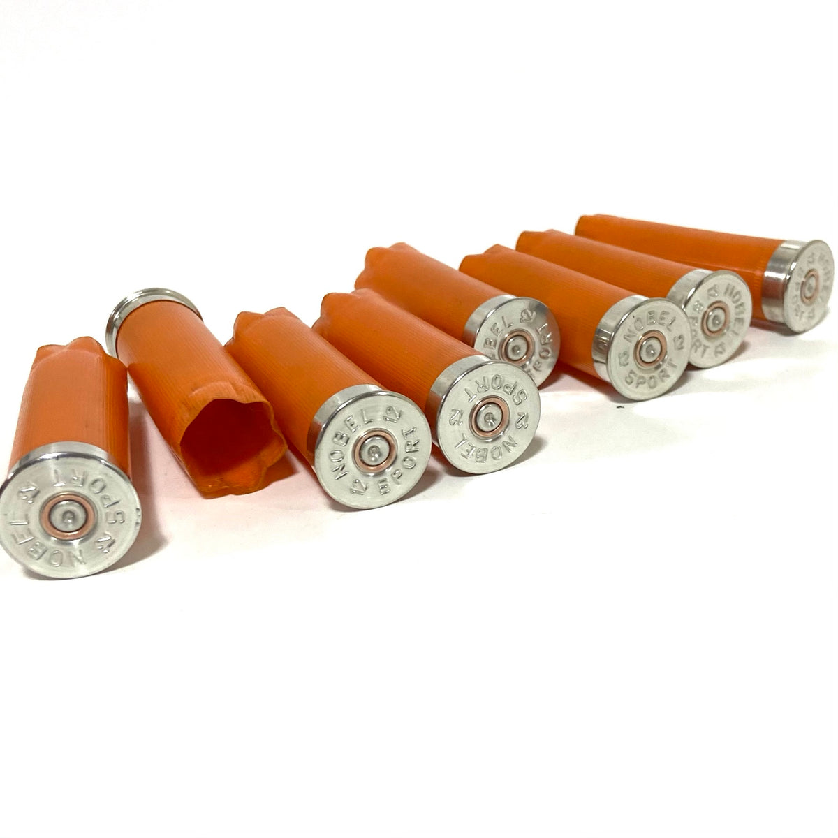 8 orange 12 gauge shotgun shells with Nobel Sport silver headstamps arranged in a row