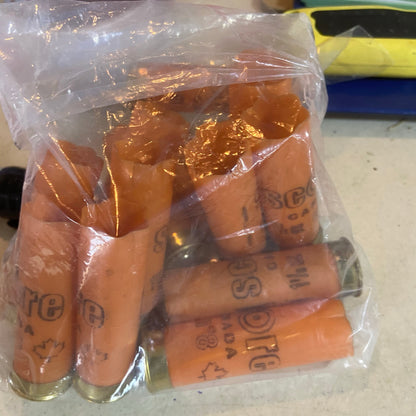 Empty orange Score shotgun shells with gold bases in a clear plastic bag