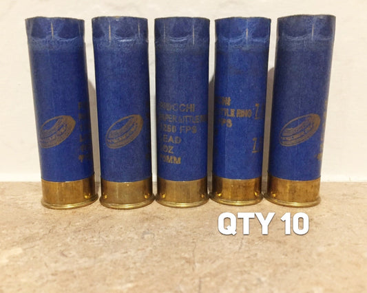 5 blue paper 12 gauge shotgun shells with brass bases standing in a row labeled QTY 10