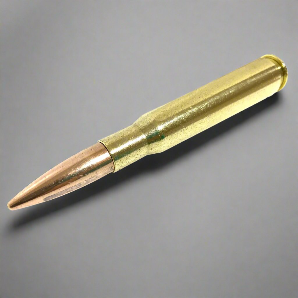 A single 50 caliber weighted paperweight with a polished brass casing and copper bullet lying diagonally against a grey background.
