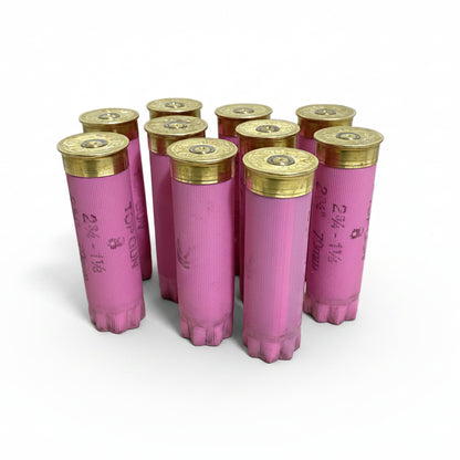 Nine pink Federal Top Gun empty hulls standing upright with brass primer ends facing up, white background.