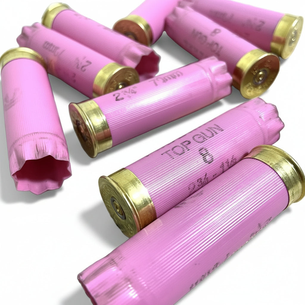 Several pink Federal Top Gun shells scattered on a white surface, showing gold bases, spent primers and crimped tops.