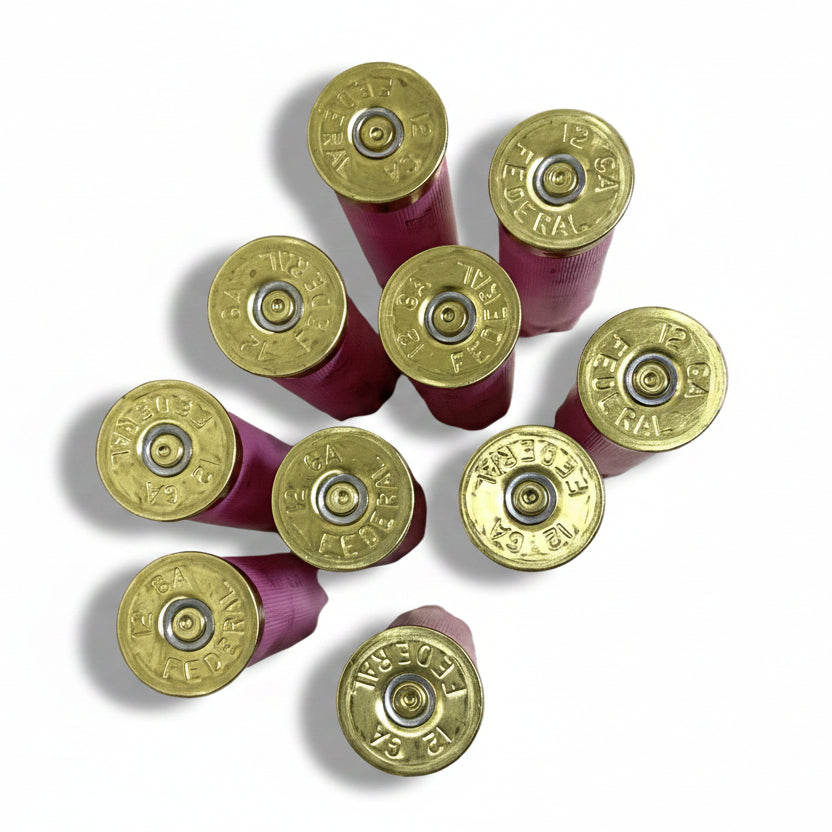 Nine pink Federal empty shells viewed from above, showing brass headstamps stamped Federal 12 gauge and spent primers.