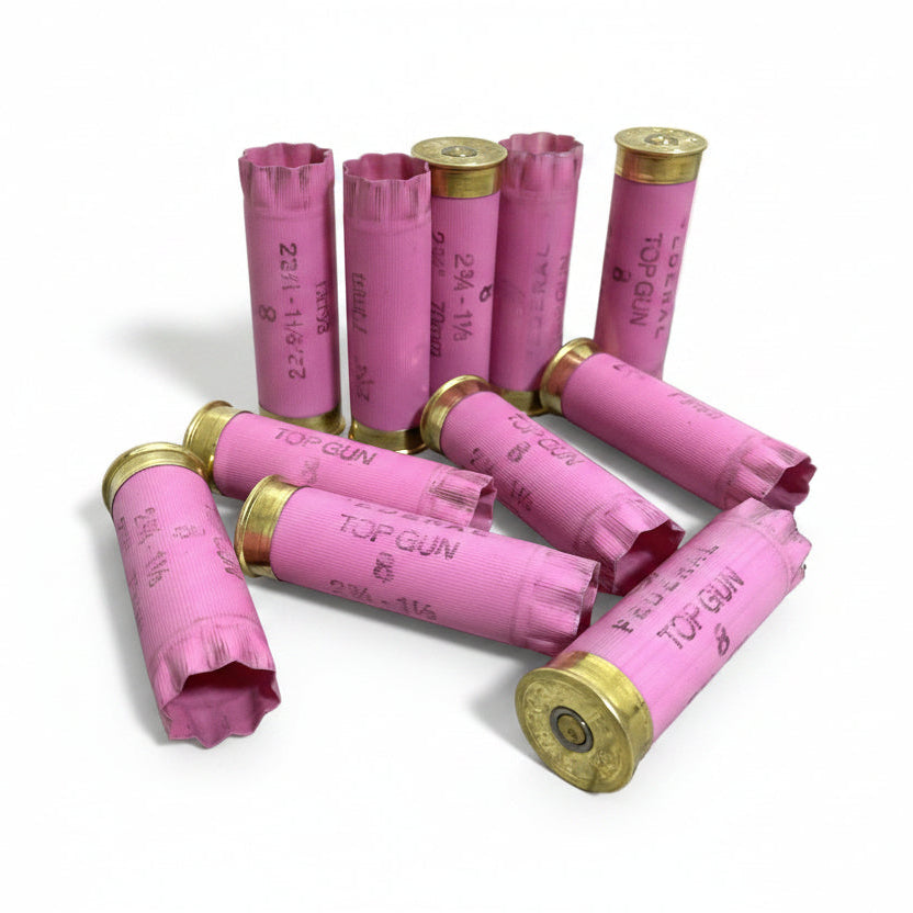Pink Federal Top Gun hulls, some standing upright and others lying down, against a white background.