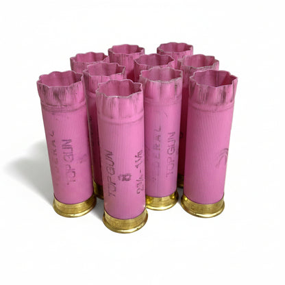 Nine pink Federal Top Gun casings standing upright, showing  8 star-crimped tops and brass bases below white background.