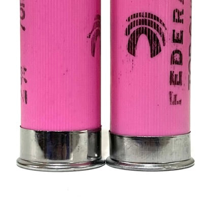 Close-up of two pink Federal 12 gauge empty shotgun shells with silver bases