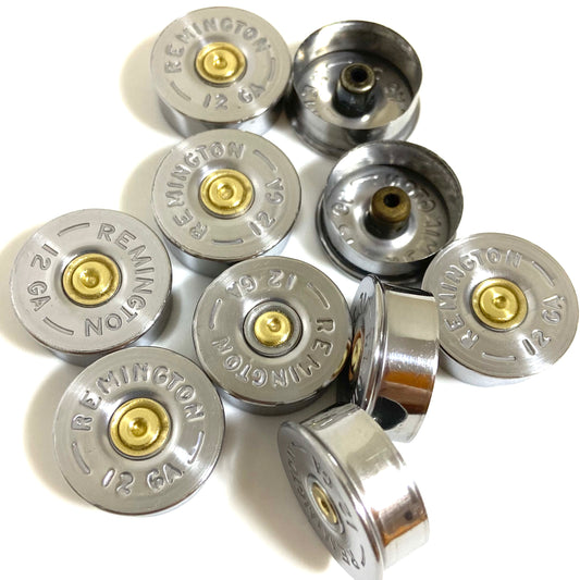 Group of polished silver 12 gauge shotgun shell bottoms on white background showing top stamped face and side profile.