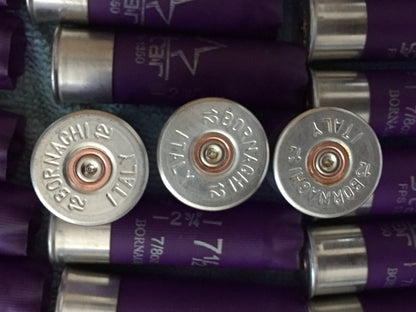 3 silver heads of purple shotgun shells viewed close-up showing Bornaghi Italy 12 headstamp text