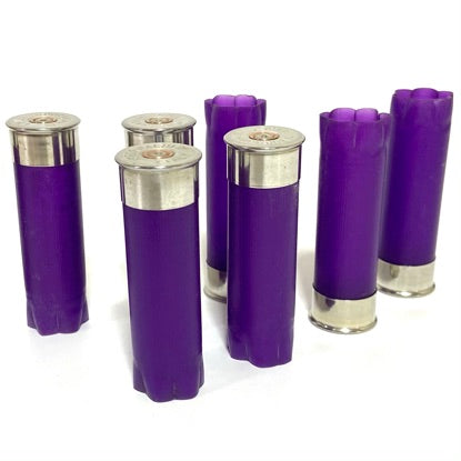 Purple empty 12-gauge shotgun shell hulls standing upright on a white background