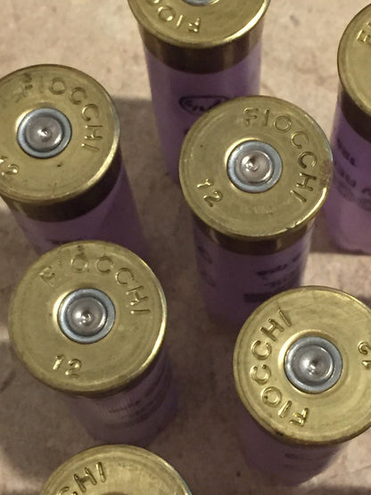 Close-up of purple Fiocchi 12 gauge shotgun shell brass base caps viewed from above