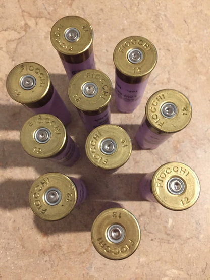 9 purple Fiocchi 12 gauge shotgun shells viewed from above showing brass base caps stamped Fiocchi 12