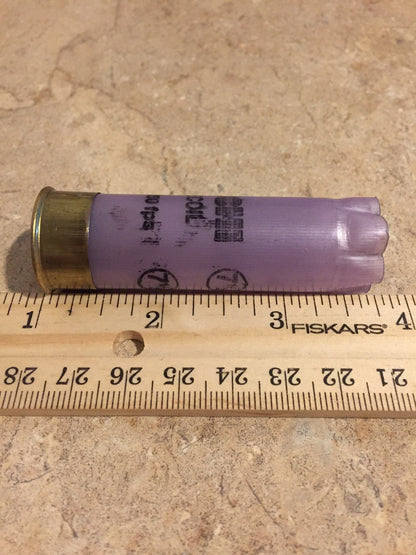 Purple Fiocchi Low Recoil 12 gauge shotgun shell measured on a ruler at approximately 2.75 inches