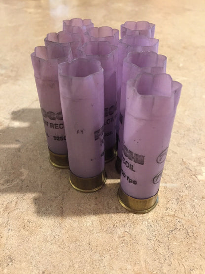 Group of purple Fiocchi 12 gauge Low Recoil shotgun shells with brass bases, standing upright on a tile surface