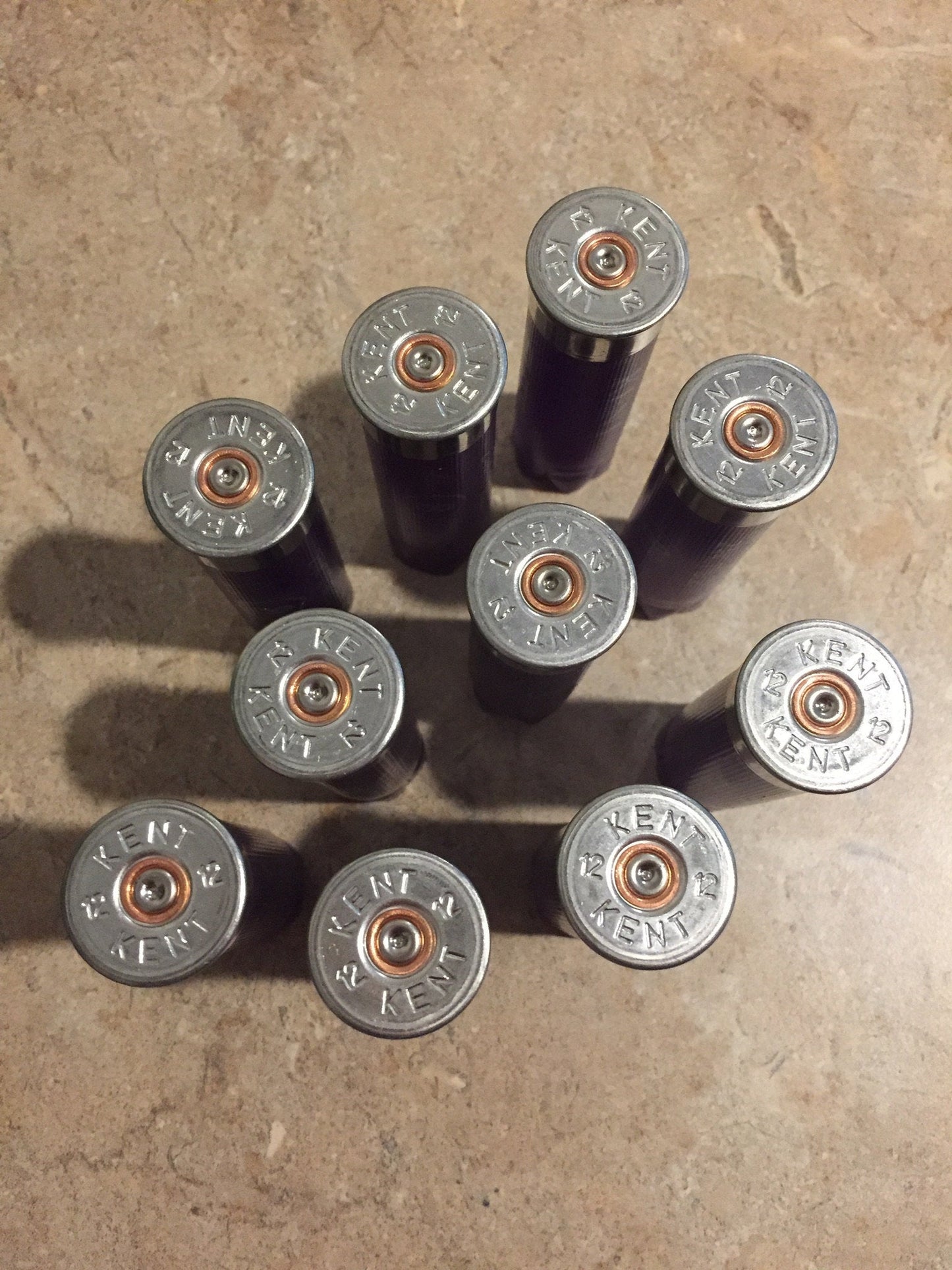 10 silver heads of purple Kent 12 gauge shotgun shells viewed from above showing KENT headstamp text