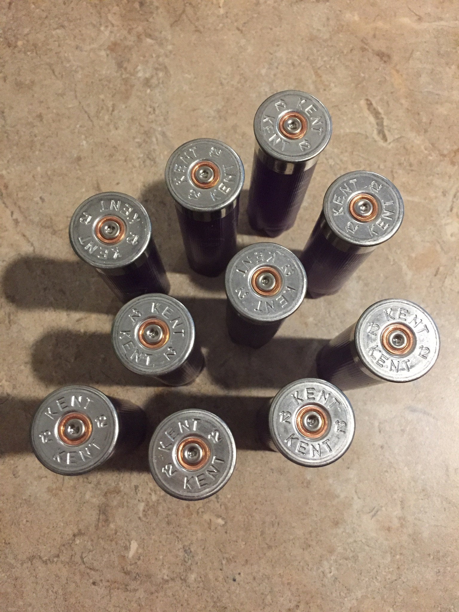 10 silver heads of purple Kent 12 gauge shotgun shells viewed from above showing KENT headstamp text