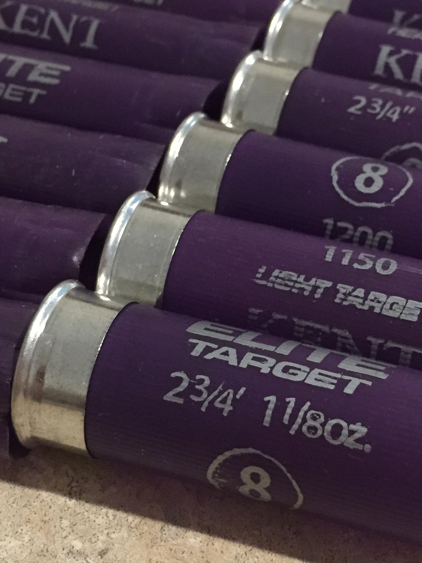 5 purple Kent shotgun shells lying diagonally showing printed text and silver heads
