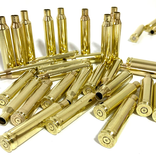 Pile of polished 7MM Remington Magnum brass rifle casings, some standing and some lying at angles