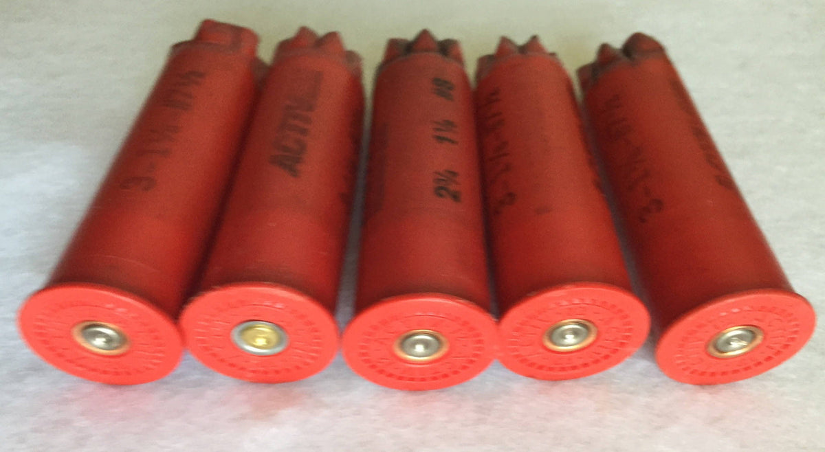 5 red plastic shotgun shells lying in a row showing brass primers and open crimped mouths
