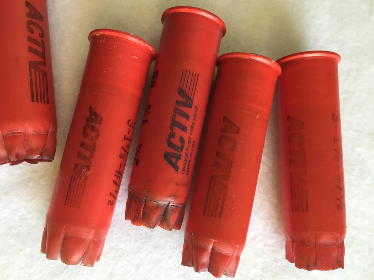 5 red plastic shotgun shells lying in a row printed "Activ" and "3-1⅛-#7½" text
