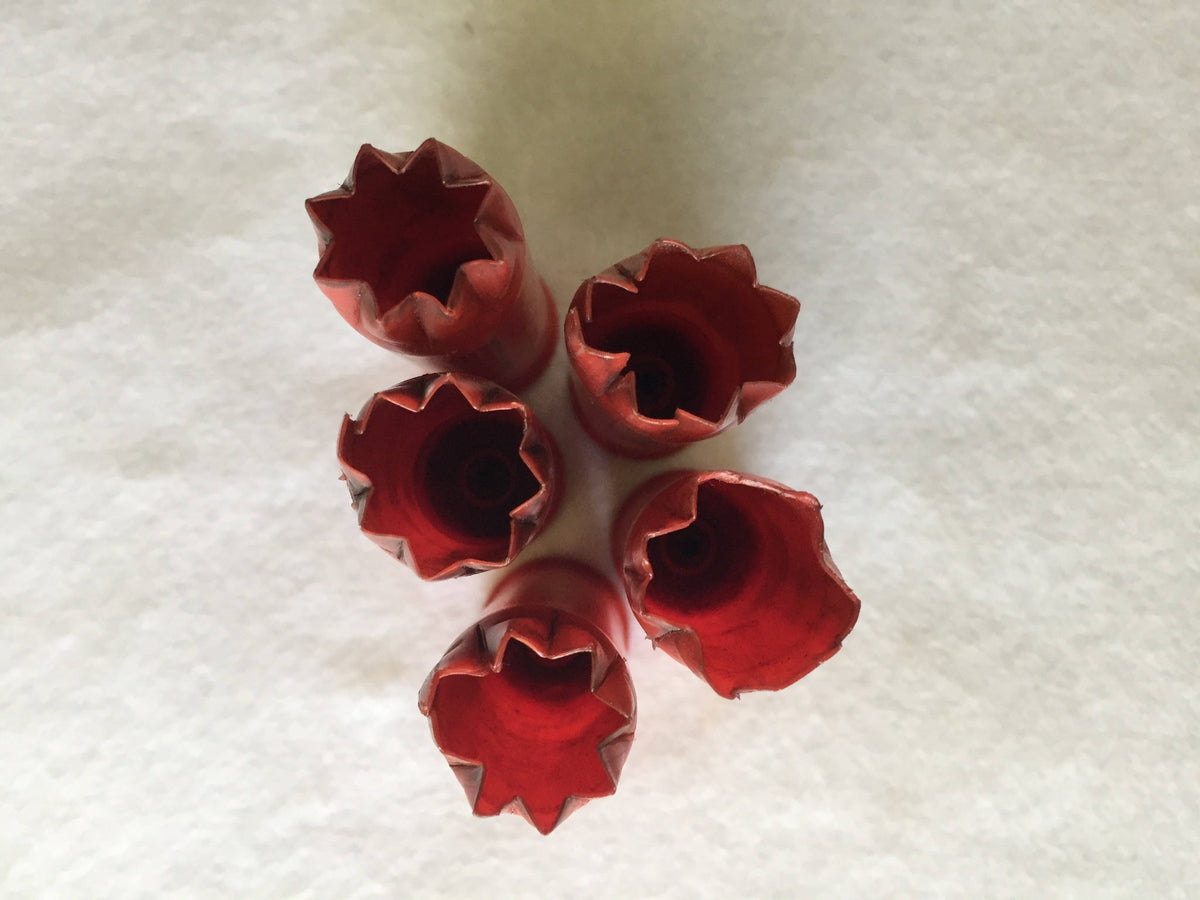 5 red plastic shotgun shells viewed from above showing open star-crimped mouths